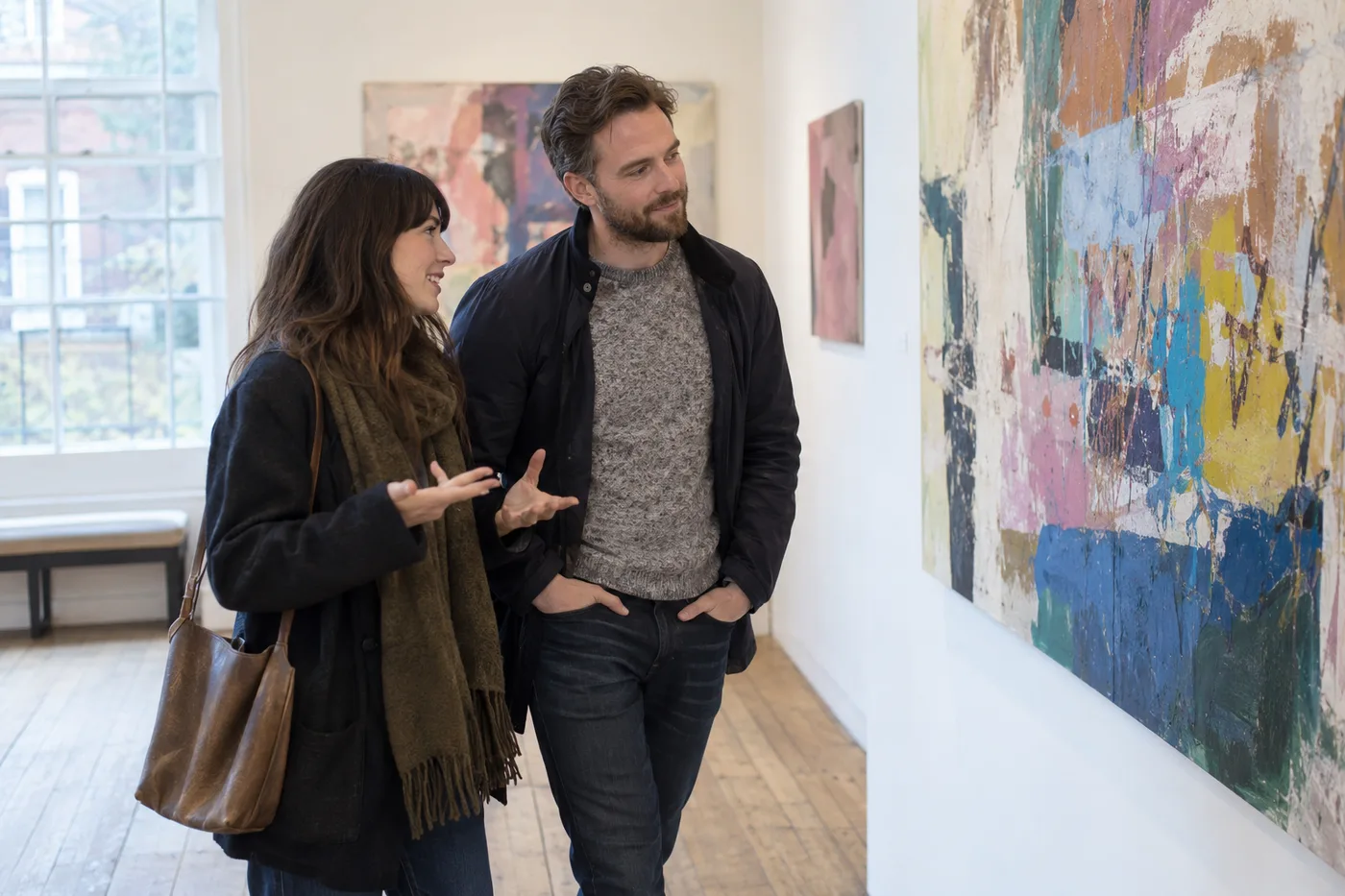 Two adults discussing a painting in a bright art gallery