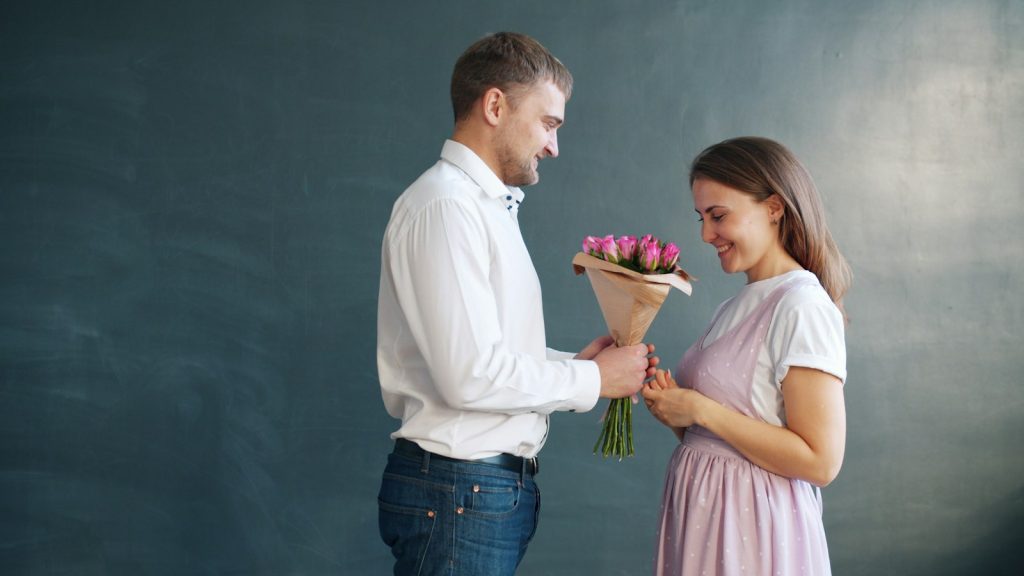 Man giving flowers to a woman as a small romantic gesture